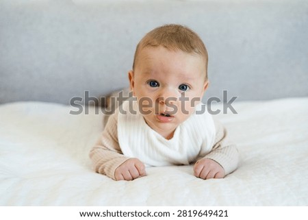 Infant practicing tummy time while lifting and holding the head independently. Early childhood developmental milestone that helps strengthen neck, shoulder, and upper body muscles.