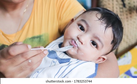 An Infant Toddler Baby Boy After Weaning Eating Solid Food With Spoon