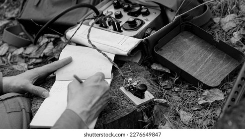 Infantry Army Soldier In World War II using Portable Radio Transceiver In Trench Entrenchment In Forest. . Headphones And Telegraph Key. Close Up Hands, Black And White Colors.