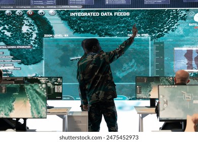 Infantry unit troopers examines satellite surveillance imagery for a mission before going into the battle. Skilled army soldiers receiving important battlefield information, training program. - Powered by Shutterstock