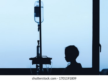 An Infected Child Stays In A Room Of The Hospital Ward To Receive The Treatment. A Bored Kid Is Looking Outside Through The Glass Window During Being Separated From Parents And Wants To Go Home.