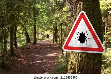 Infected ticks warning sign in a forest. Risk of tick-borne and lyme disease. - Shutterstock ID 2113458593