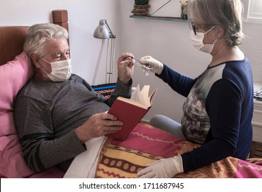 Infection Coronavirus . Senior Couple With Man Sick By Covid-19 Lying Down In Bed At Home Wearing Medical Mask. Quarantine Self Isolation Concept