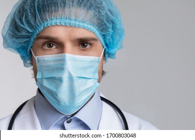 Infectious Disease Doctor. Portrait Of Confident Medical Specialist In Protective Mask And Bouffant Cap Looking At Camera Over Light Background, Crop