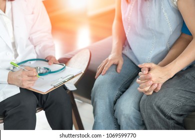 Infertility problem with marriage couple concept. A fertility doctor or reproductive endocrinologist with man and women holding hand together in therapy consult session  of inability to pregnant. - Shutterstock ID 1069599770