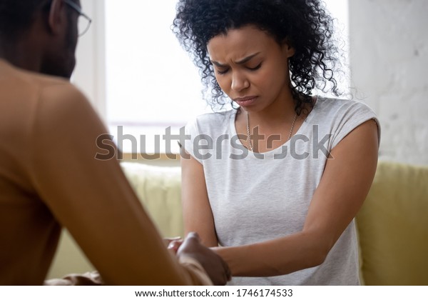Infertility of spouse, health problem, unplanned\
pregnancy husband convinces wife to have abortion decision. Break\
up divorce honest talk between people. African woman receiving\
moral support\
concept
