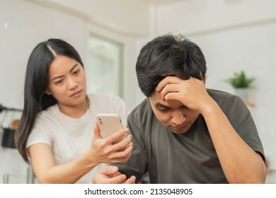 Infidelity, Suspicion Asian Young Couple Love Fight Relationship, Wife Holding Cellphone, Smartphone Cheating On Phone, Scolding Husband About Mistrust, Distrust And Jealousy When Sitting At Home.