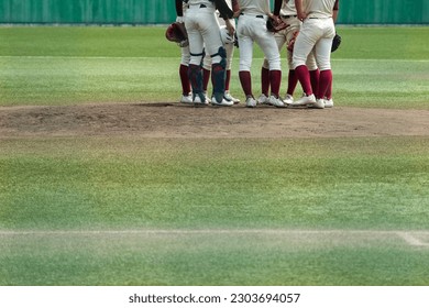 Infielders gather on the mound to discuss a pinch-hit situation during a baseball game. - Powered by Shutterstock