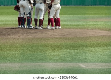 Infielders gather on the mound to discuss a pinch-hit situation during a baseball game. - Powered by Shutterstock