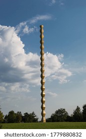 Infinity Column or Endless Column, the work of the famous sculptor Constantin Brancusi. Beautiful view of the park under a beautiful blue sky with clouds. Targu Jiu, Romania, July 15, 2020