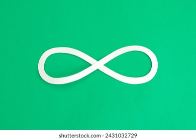 Infinity loop symbol paper cut on bright green background