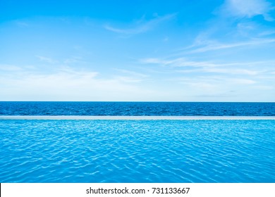 Infinity swimming pool with sea and ocean view on blue sky background