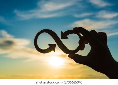 Infinity symbol in the hand of a businessman on a sunset sky background. Business concept idea, innovation, success and achievement, creative.