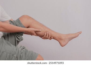 Inflammation of the calf of the leg held by the hand. Pain that attacks the calf of a young man's leg. health concept on leg bones.