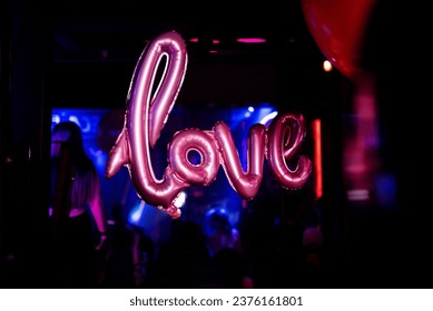 Inflatable balloon with the inscription Love at a party in a nightclub, bar
