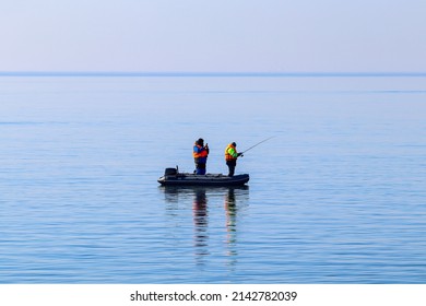 From an inflatable boat, two men fishermen catch a Baltic herring - Powered by Shutterstock