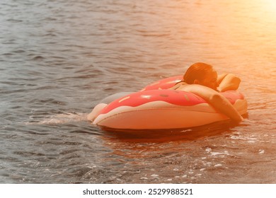 Inflatable Boat Water Fun Summer Vacation - Two people enjoying a ride on a pink inflatable boat in the water on a sunny day. - Powered by Shutterstock