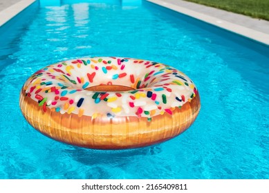 Inflatable circle donut in the pool. Clear blue water in the pool. Relax in the backyard of a country house