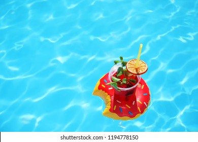 Inflatable Drink Holder With Cocktail In Swimming Pool On Sunny Day. Space For Text