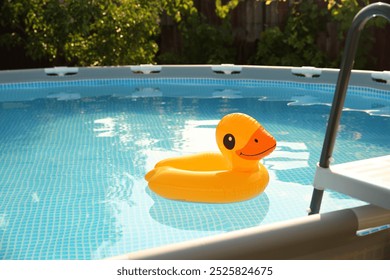 Inflatable duck shaped ring on water in above ground swimming pool outdoors