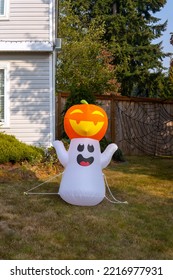 Inflatable Figure Of Ghost With Pumpkin Near The House. Outdoor Halloween Decoration