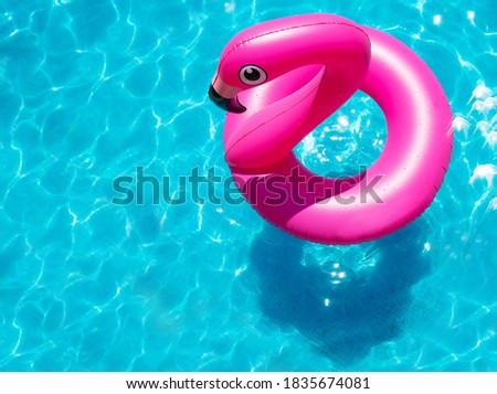 Inflatable flamingo buoy swim in the swimming pool view from above
