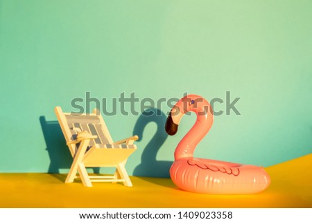 Inflatable Flamingo and deckchair on a blue background, pool float party, trendy summer concept