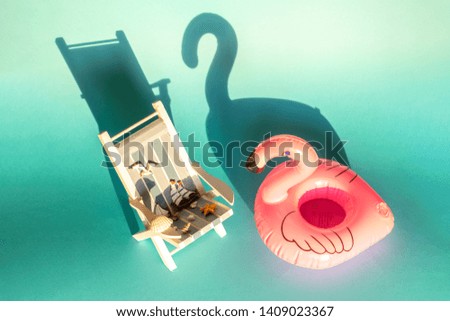 Inflatable Flamingo and deckchair on a blue background, pool float party, trendy summer concept