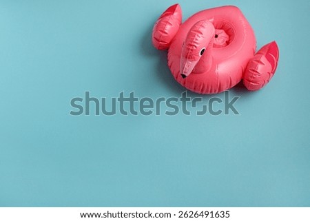 Inflatable flamingo pool float on blue background. Top view. Copy space