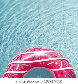 Inflatable Float Rubber Ring In The Form Of A Pink Donut In The Blue Water Of The Pool.