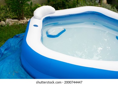 Inflatable Pool For Relaxation Full Of Water In Backyard On Protective Membrane. Some Garbage In Pool. Cleaning And Filtering Water In Small Pools 