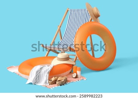 Inflatable ring, deck chair and beach accessories on blue background. Travel concept