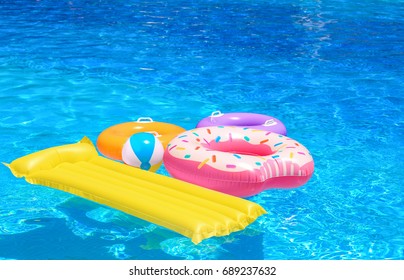 Inflatable rings, mattress and ball in blue swimming pool - Powered by Shutterstock