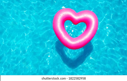 Inflatable rose heart buoy swim in the swimming pool view from above - Powered by Shutterstock