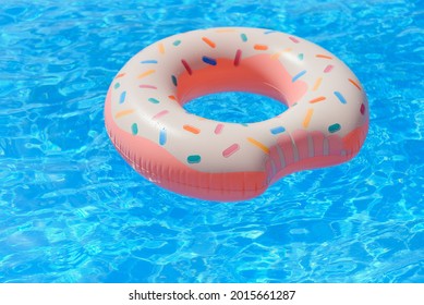 Inflatable swim ring in shape of donut floating in pool