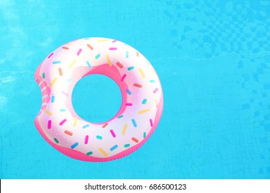 Inflatable swim ring in shape of donut floating in pool