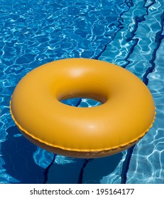 Inflatable Yellow Inner Tube Floating In Clear Blue Waters