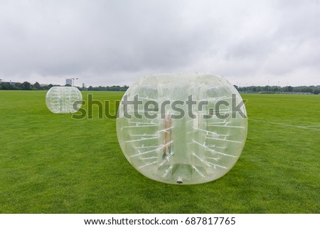 Inflatable zorbes for soccer playing on a green lawn in Copenhagen, Denmark - July 27, 2017