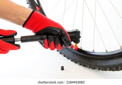 Inflate A Flat Tire Of A Bicycle With A Hand Pump, Close-up, On An Isolated White Background