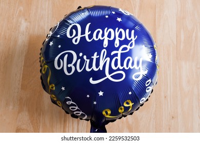 An inflated blue balloon spells Happy Birthday. - Shutterstock ID 2259532503
