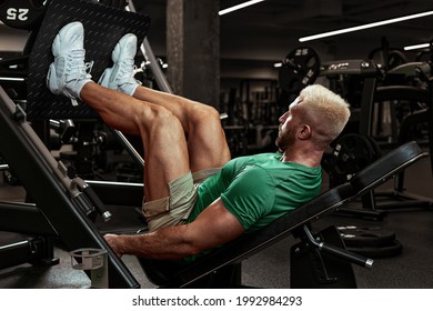 Inflated Young Athlete Doing Leg Exercises In The Gym, Swinging Legs, Muscle Mass Balance, Warm-up Before Training