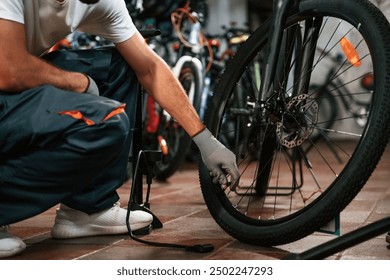 Inflates a tire with hand pump. Close up view of man's hands that is repairing bicycle. - Powered by Shutterstock