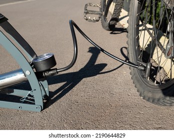 Inflating Bike Tire Outdoors. Pumping Up Bicycle Tyre. Closeup
