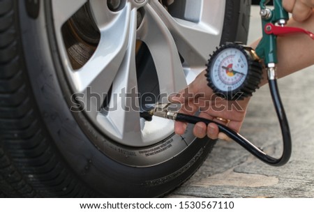 Inflating the tires car and checking air pressure.
