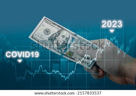 inflation in 2022 and 2023. man holds one hundred dollar bill in hand against of graph chart of rising inflation rates. dollar hyperinflation on dark blue background. decreasing purchasing power Foto stock © 