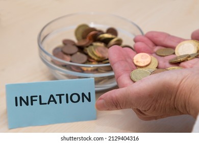 Inflation Concept. Hand Holding Coins And Half Empty Jar Of Coins