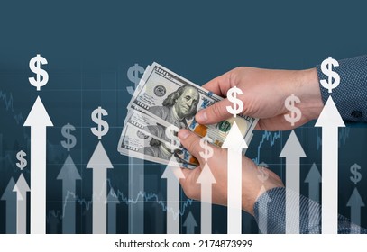 Inflation. Hands With Banknotes Of American Dollars Against The Background Of Arrows And Dollar Signs. Monetary Inflation. Dollar Sign And Arrows Indicating An Increase In Inflation