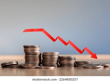 Inflation. The recession of the economy and the euro. The concept of economic collapse and the collapse of the stock exchange in the euro zone. Stacks of coins and a graph arrow pointing down. 