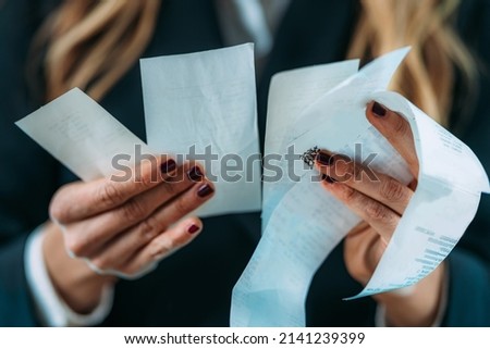 Inflation rising, costs increasing. Business woman holding Rising costs, declining standard of living, worried woman looking at increased costs on a printed receipt