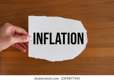 Inflation, woman hand holds a piece of paper with a note. Rising prices, interest rates and economic depression. - Shutterstock ID 2359877545